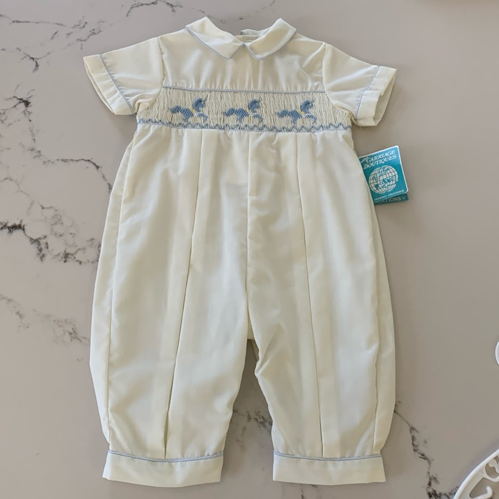New, with tags, infant boy’s smocked one piece with snap leg closure.